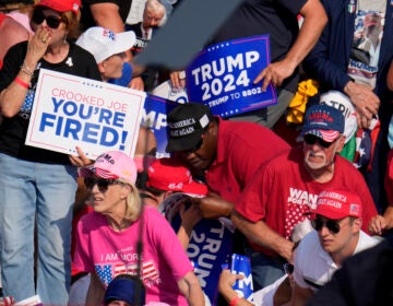 Members of the crowd react as U.S. Secret Service agents surround Republican presidential candidate former President Donald Trump at a campaign event in Butler, Pa., on Saturday, July 13, 2024. (AP Photo/Gene J. Puskar)