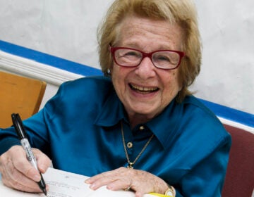 FILE - Dr. Ruth Westheimer signs a copy of her book 
