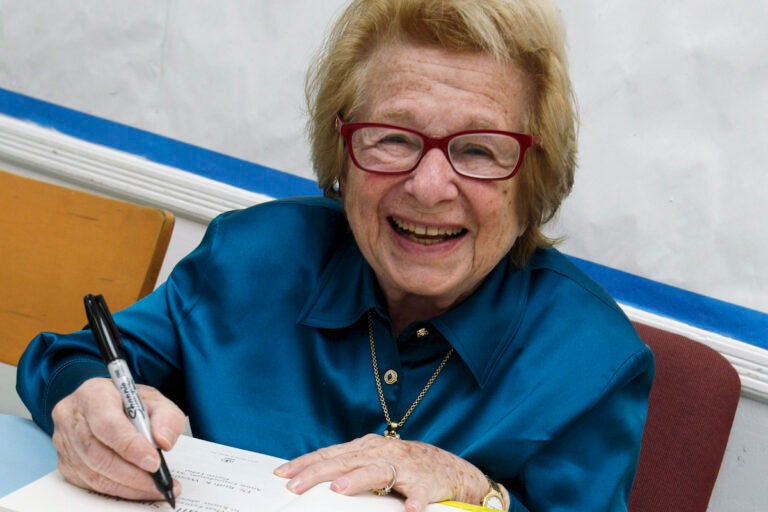 FILE - Dr. Ruth Westheimer signs a copy of her book 