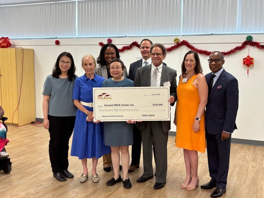 Officials posing with a giant check