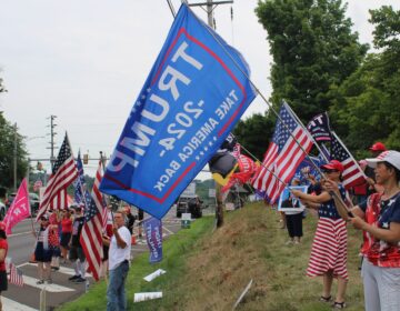 Dozens of Trump supporters waved flags and signs by the side of the road in Doylestown on July 20, 2024. (Emily Neil/WHYY)