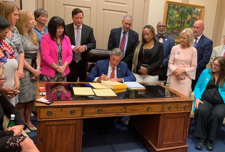 John Carney signing the budget