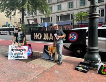 climate activists hold signs saying Hydrogen is going nowhere and No Mach2