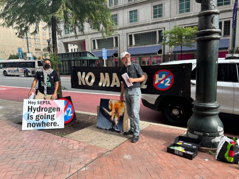 climate activists hold signs saying Hydrogen is going nowhere and No Mach2