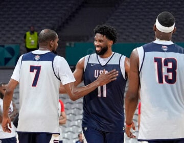 United State's Kevin Durant, left, pats Joel Embiid, center, after practice as Bam Adebayo watches during men's basketball practice at the 2024 Summer Olympics, Wednesday, July 24, 2024, in Villeneuve-d'Ascq, France. (AP Photo/Mark J. Terrill)