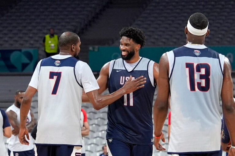 United State's Kevin Durant, left, pats Joel Embiid, center, after practice as Bam Adebayo watches during men's basketball practice at the 2024 Summer Olympics, Wednesday, July 24, 2024, in Villeneuve-d'Ascq, France. (AP Photo/Mark J. Terrill)
