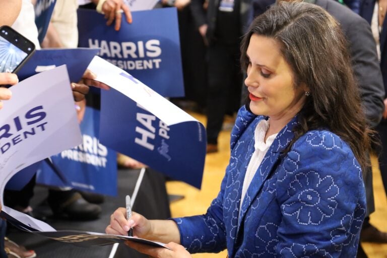 Gov. Gretchen Whitmer of Michigan signs campaign signs at a campaign event in Montgomery County for Kamala Harris in Ambler, Pa. (Carmen Russell-Sluchansky)