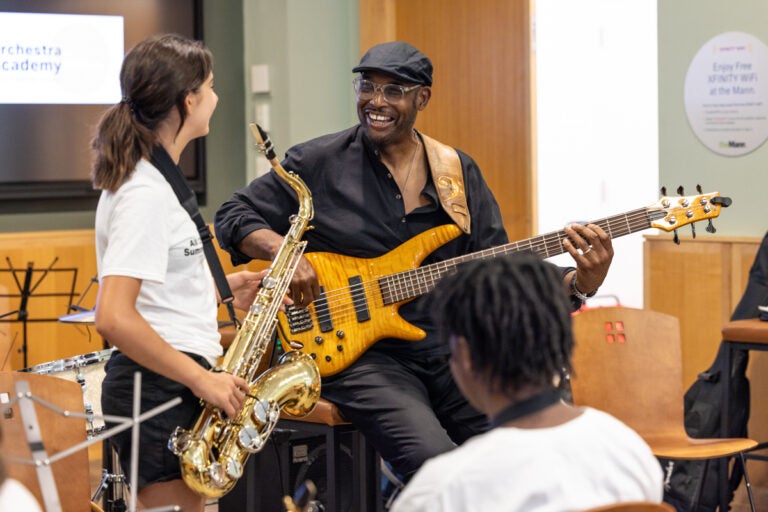 Gerald Veasley hold a bass and Adrianna Hanes holds a saxophone