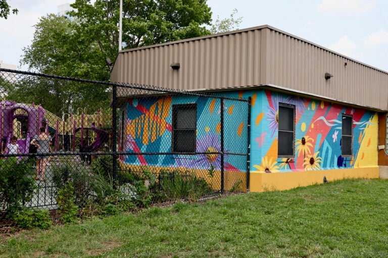 A colorful mural is shown on two sides of a building