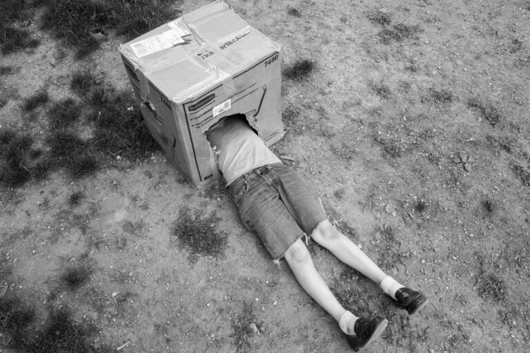 a kid on the ground with their head in a box