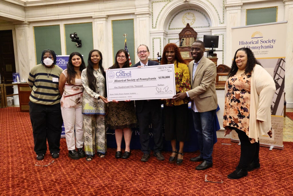 Posing with a giant check in City Hall