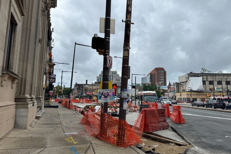 orange construction tape and barriers on the street and sidewalk