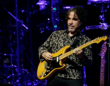 John Oates playing guitar on stage