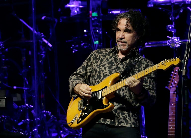 John Oates playing guitar on stage