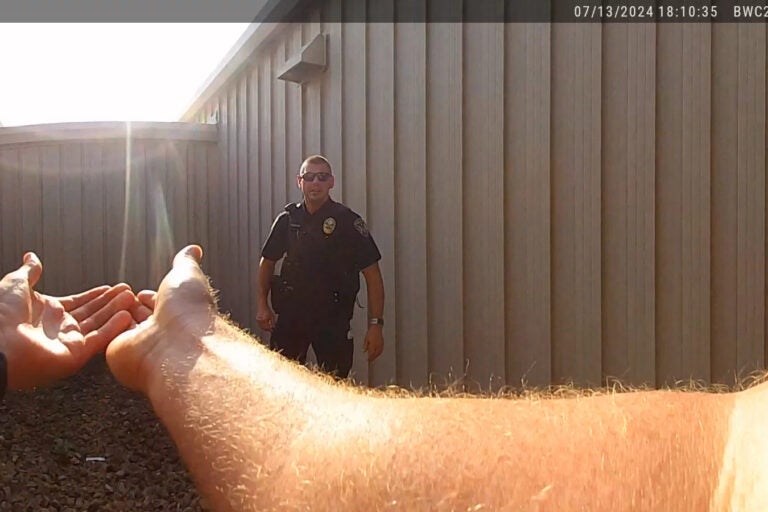 an officer holds open hands in front of another officer