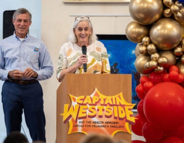 John Carney and a woman stand behind a podium