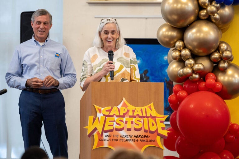 John Carney and a woman stand behind a podium