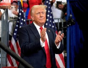 Donald Trump claps in front of a crowd