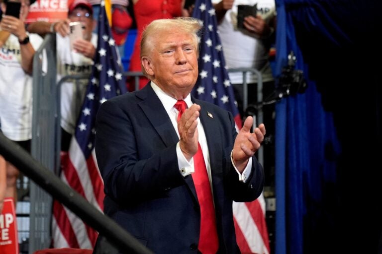 Donald Trump claps in front of a crowd