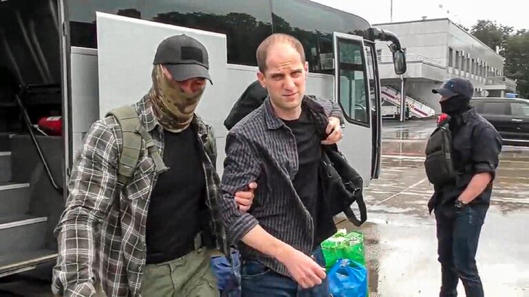 Evan Gershkovich is escorted by a Russian Federal Security Service agent