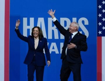 Kamala Harris and Tim Walz wave