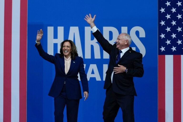 Kamala Harris and Tim Walz wave