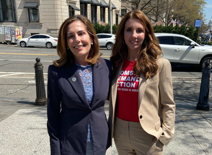 Kathy Jennings and Shannon Watts pose for a photo on the sidewalk