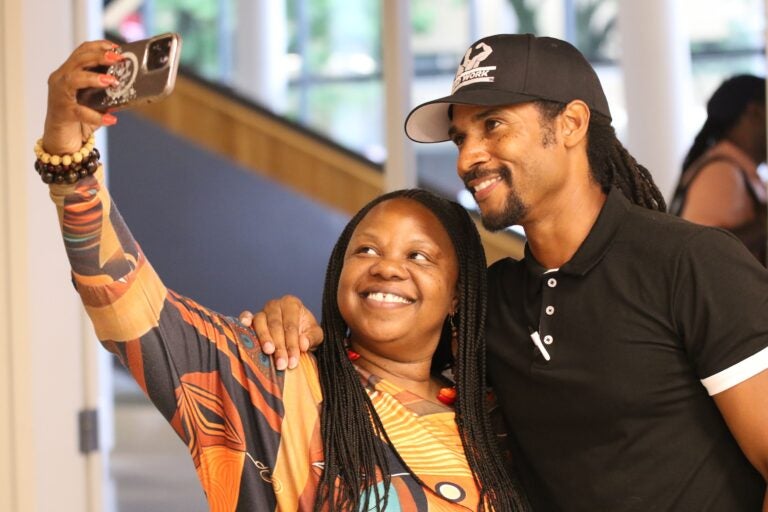 Yvonne Orr holds her phone up in front of Mike Africa Jr.