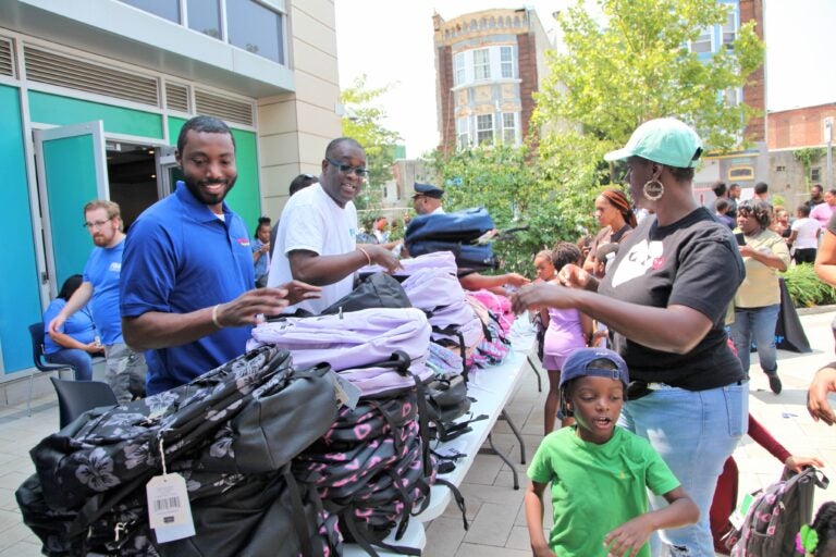 Donta Rose and and Kelvin Jeremiah at a table with backpacks