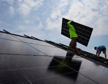 A crew installs a solar array on the roof of a home in Frankfort, Ky., in 2023. (Michael Conroy/AP)