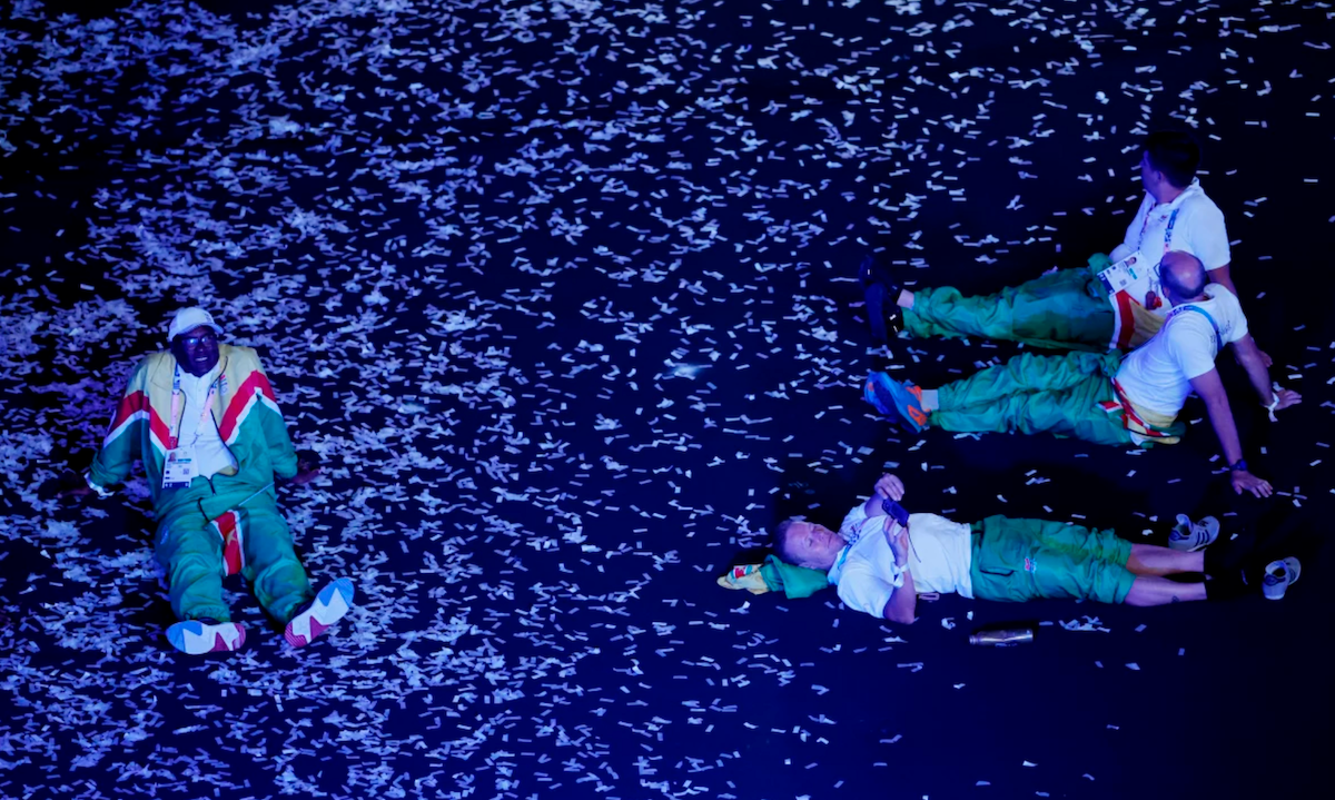 Athletes of Suriname sit on the floor during the closing ceremony on Sunday.