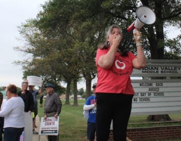 Stephanie Jamison speaks into a microphone at a rally ahead of the Souderton Area School District board meeting on Aug. 29, 2024