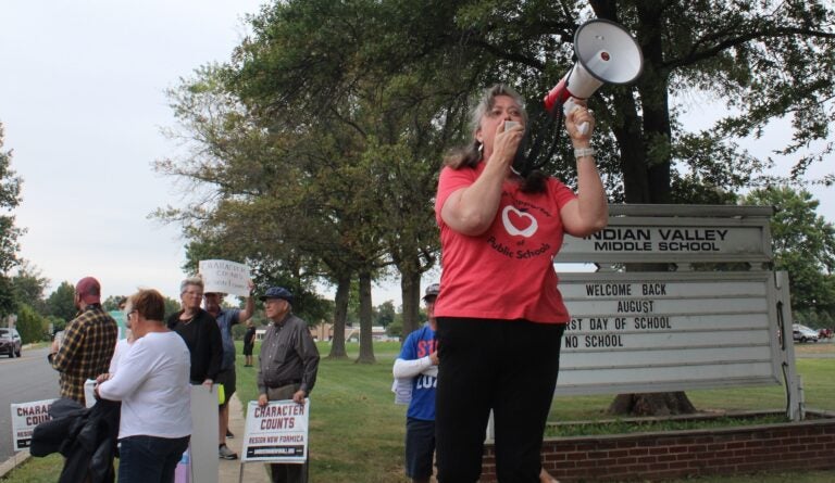 Stephanie Jamison speaks into a microphone at a rally ahead of the Souderton Area School District board meeting on Aug. 29, 2024