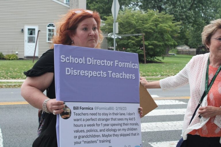 Jane Spigel holds up a sign that says Bill Formica disrespects teachers