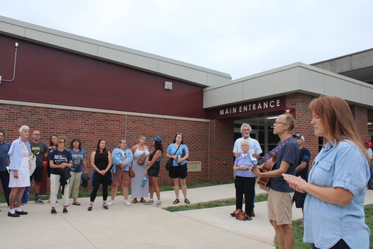 A group of Bill Formica supporters stand outside a school board meeting singing Christian songs