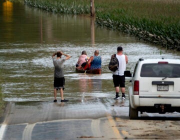 People paddle through a flooded area of New York following Tropical Storm Debby