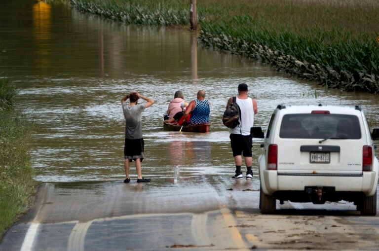 People paddle through a flooded area of New York following Tropical Storm Debby