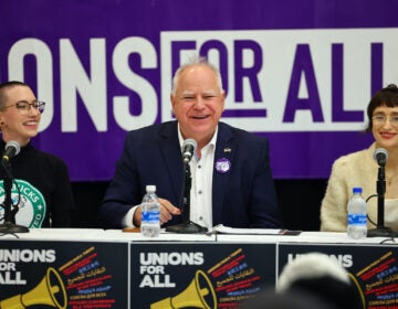 Tim Walz speaking at a table