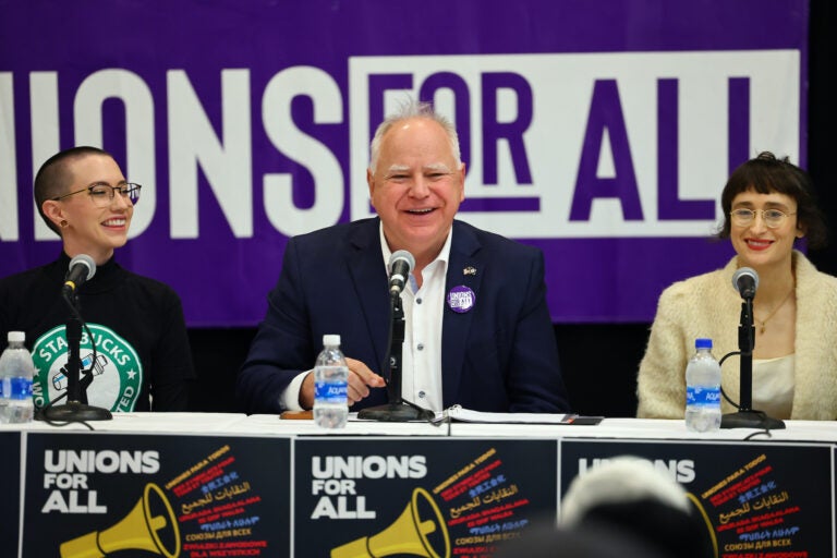 Tim Walz speaking at a table