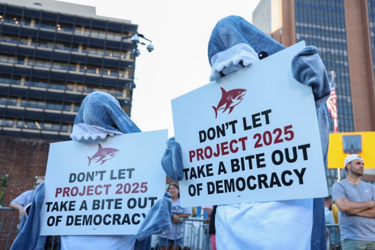 protesters in shark costumes