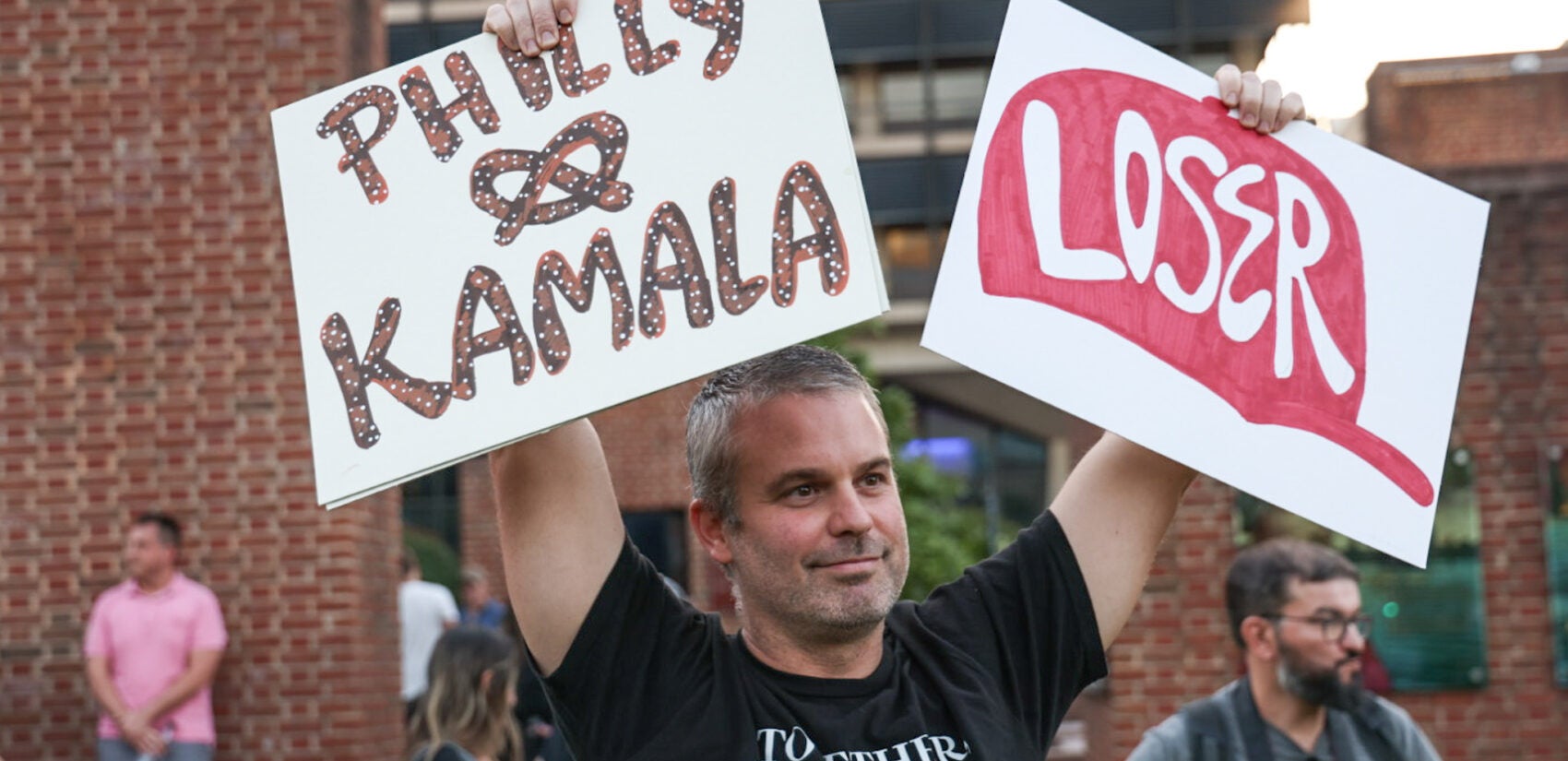 Andy Metzger holds up a sign in support of Kamala Harris