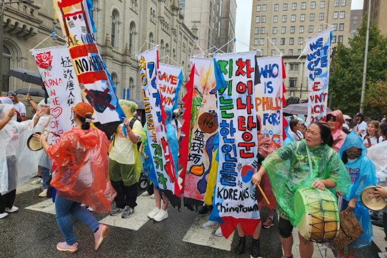 Members of the Korean American Woori Center march against 76er Place