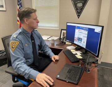 New Jersey State Police Major Tom Wieczerak sits at a desk working on a computer