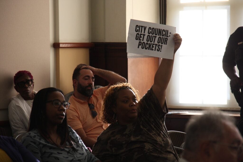 Camden resident holds up sign