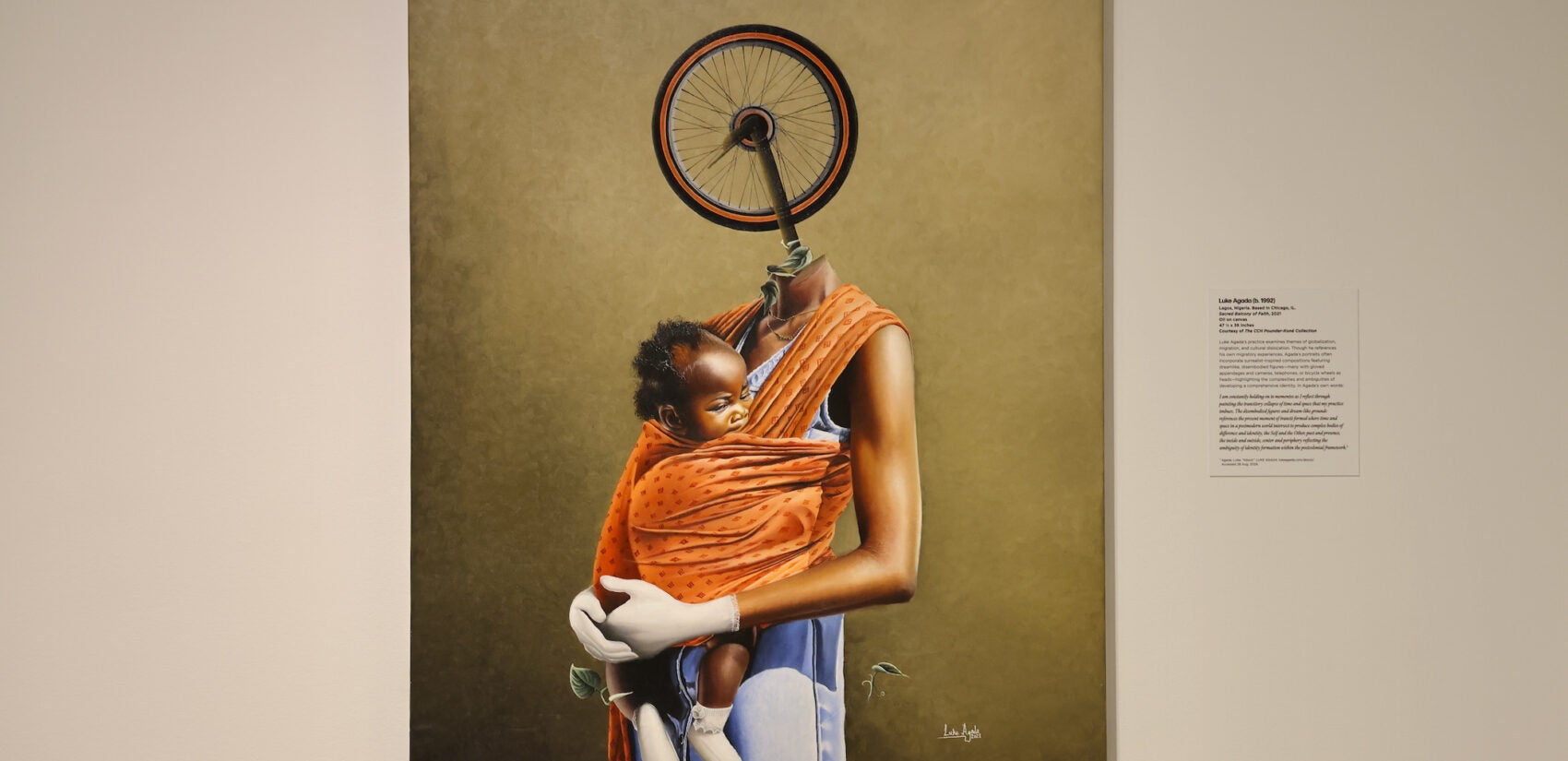 A painting of a Black woman with a bicycle wheel for a head holding a baby