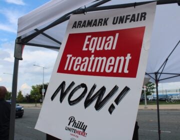 a sign reads ARAMARK UNFAIR EQUAL TREATMENT NOW!