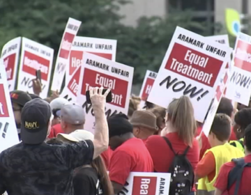 Aramark workers hold up protest signs