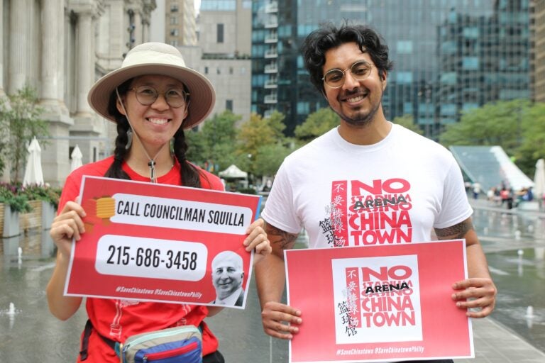 Jenny Zhang and Mohan Seshadiri hold signs and smile