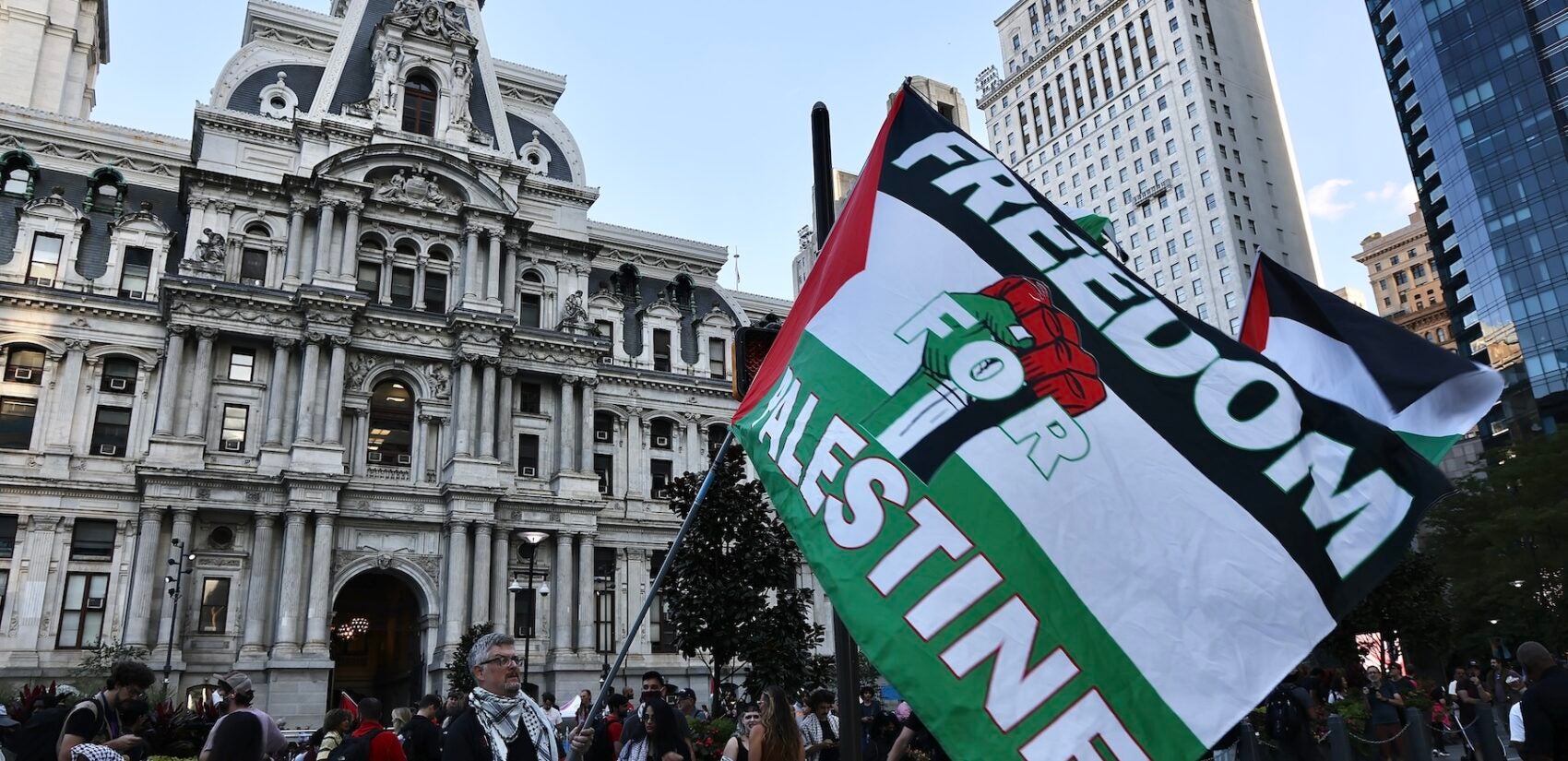 A protester holding a large pro-Palestine flag