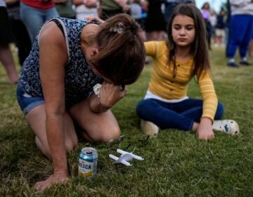 Brandy Rickaba and her daughter Emilie pray during a candlelight vigil for the slain students and teachers at Apalachee High School, Wednesday, Sept. 4, 2024, in Winder, Ga.